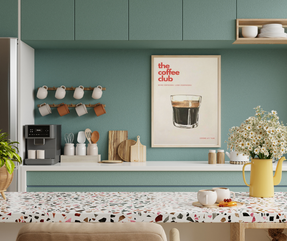 Modern kitchen with green cabinets, a coffee-themed poster, and a floral arrangement.